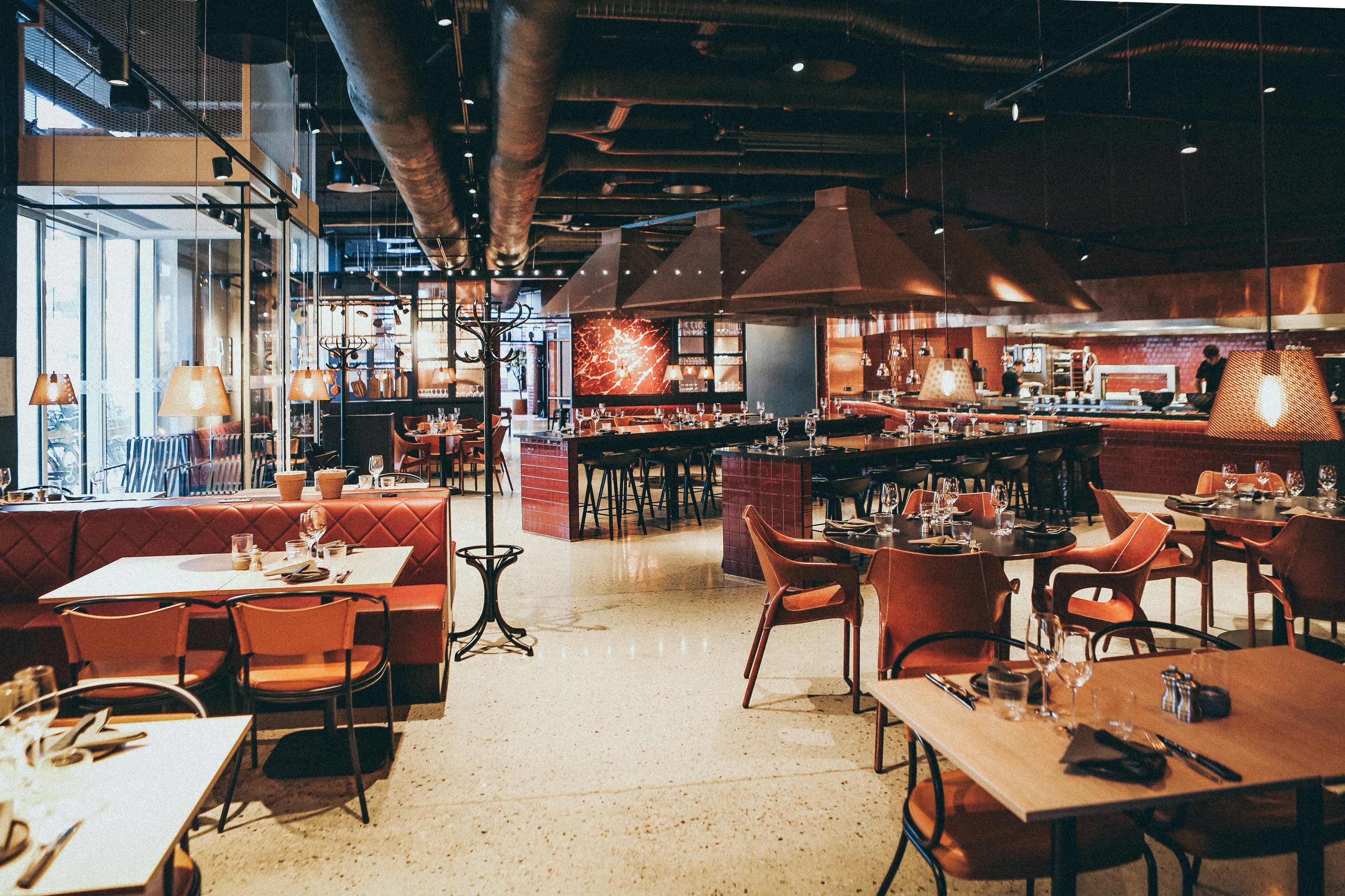 Warm restaurant interior with copper tones and an open kitchen